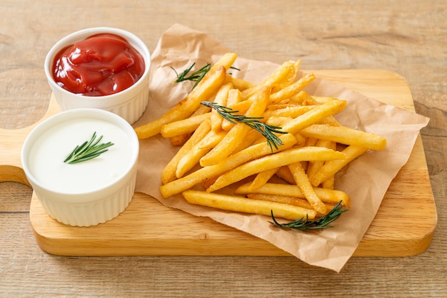 Frites ou chips de pommes de terre avec crème sure et ketchup