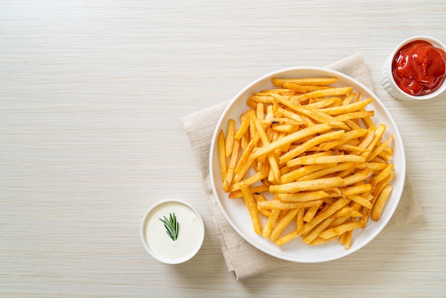 Frites ou chips de pommes de terre avec crème sure et ketchup