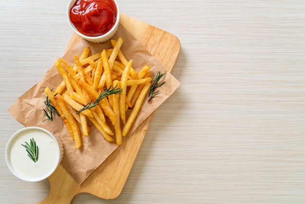 Frites ou chips de pommes de terre avec crème sure et ketchup