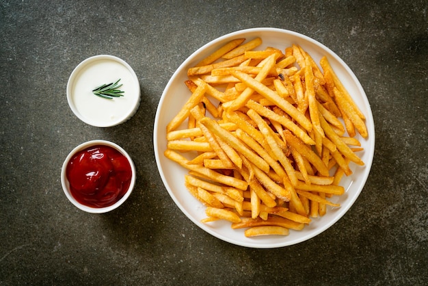 Frites ou chips de pommes de terre avec crème sure et ketchup