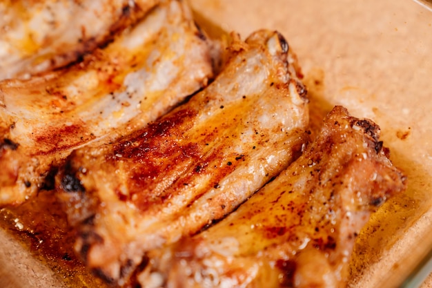 Frites avec des côtes de porc aux épices dans une plaque à pâtisserie en verre sur un fond en bois. viande cuite à la maison.