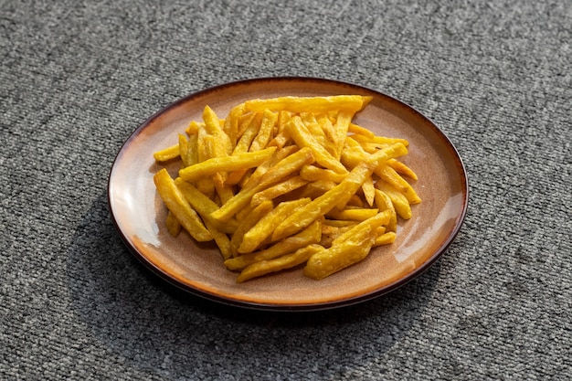 Frites croustillantes ou croustilles avec trempette mayo et sauce tomate servies dans une assiette vue latérale