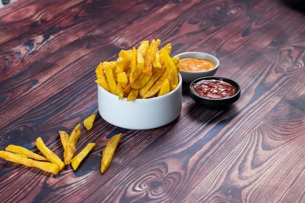 Frites croustillantes ou croustilles avec trempette mayo et sauce tomate servies dans une assiette vue latérale