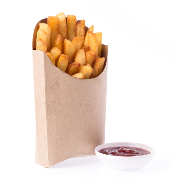 Frites dans un sac en papier avec sauce tomate isolé sur fond blanc