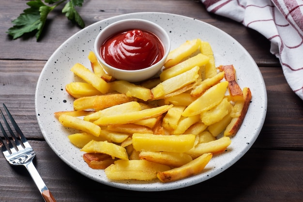 Frites frites avec sauce tomate sur une assiette