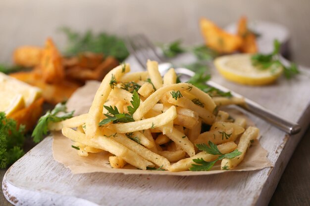 Frites sur papier calque à bord sur table en bois