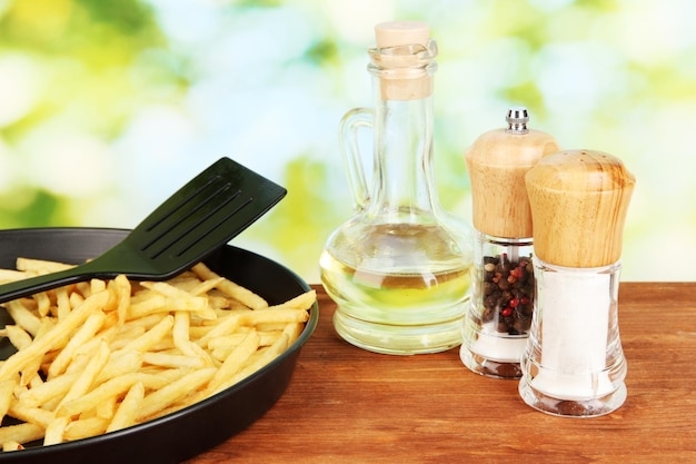 Frites de pommes de terre dans la poêle sur fond vert libre