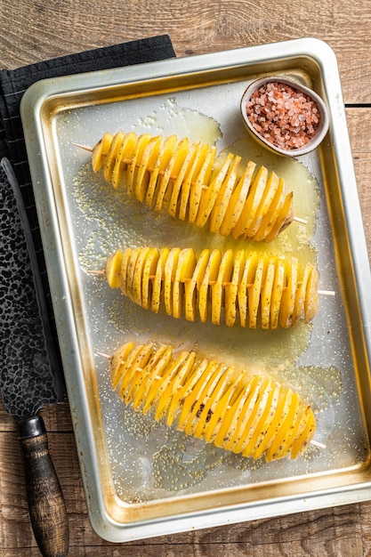 Frites de pommes de terre Tornado ou Twist crues non cuites. Fond en bois. Vue de dessus.