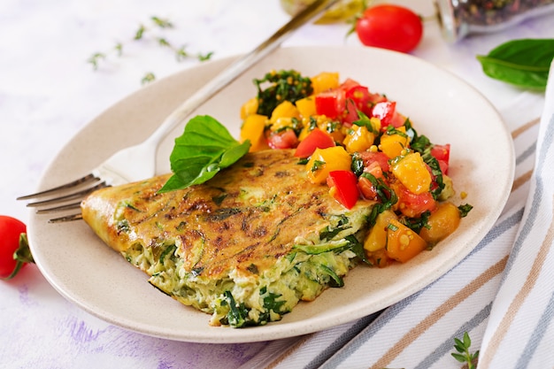 Frittata aux courgettes, fromage, basilic et salsa de tomates. Omelette italienne.