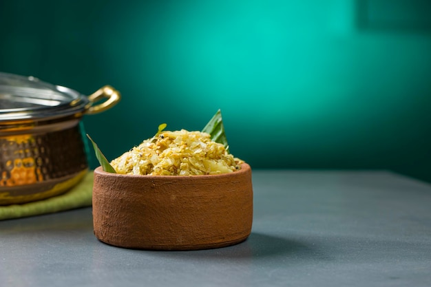 Friture de chou ou plat sauté pour les repas du kerala qui est une nourriture végétarienne très savoureuse disposée dans une vaisselle en terre qui est placée sur un fond texturé gris