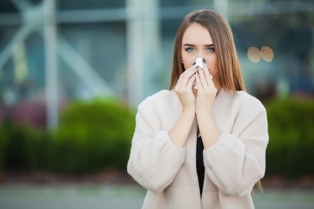 Froid et grippe Femme bouleversée avec la grippe et les tissus à l'extérieur