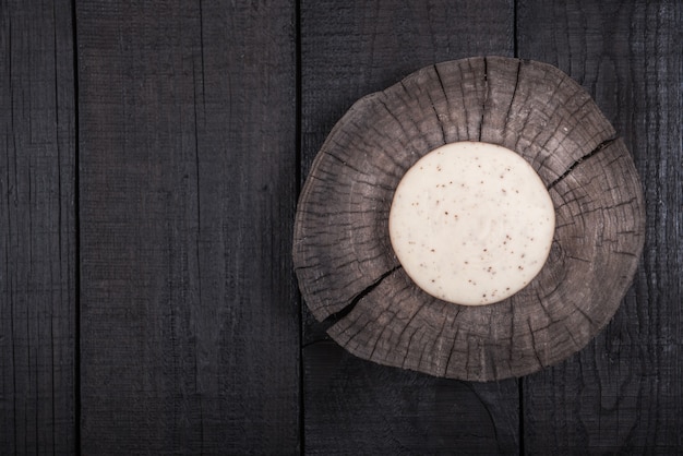 Fromage au lait blanc avec des graines sur une extrémité en bois d'un arbre