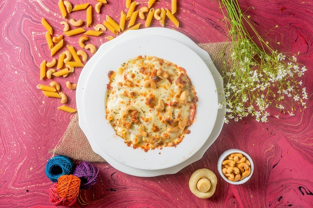 Fromage au poulet Pâtes aux noix de cajou dans une assiette vue de dessus sur fond de bois