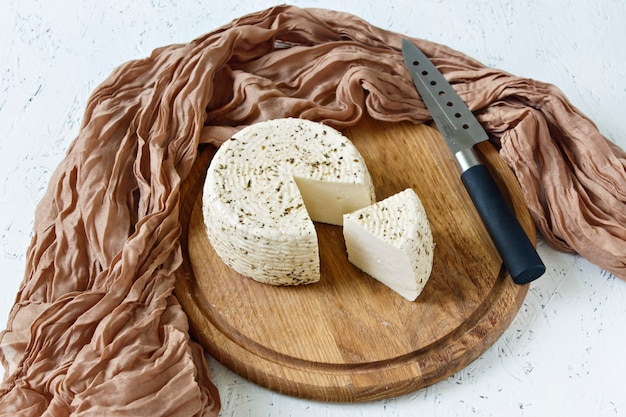 Fromage blanc sur une planche de bois sur un fond blanc