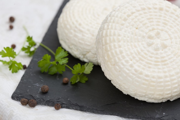 Fromage blanc rond fait maison lait traditionnel produit laitier crémeux servi avec des herbes