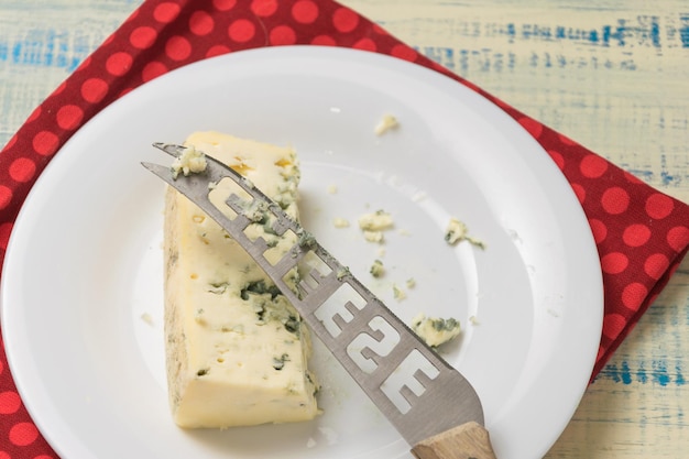 Fromage bleu et un couteau avec l'inscription fromage sur une assiette