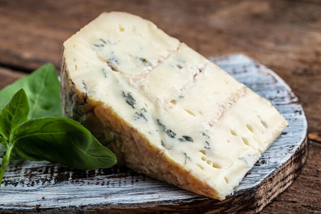 Fromage bleu danois Délicieux fromage bleu sur fond de bois et morceaux de fromage Dorblu de toile de jute Fond de recette alimentaire Gros plan