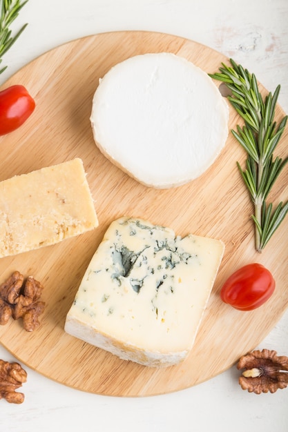 Fromage Bleu Et Divers Types De Fromage Au Romarin Et Tomates Sur Planche De Bois Sur Une Surface En Bois Blanc