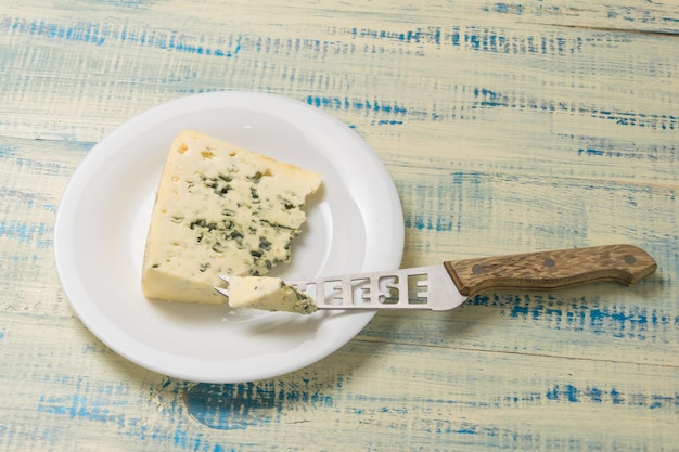 Fromage bleu avec moule sur une assiette avec un couteau