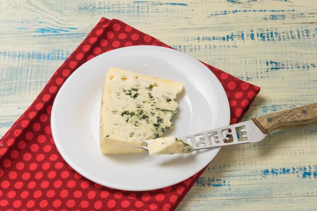 Fromage bleu avec moule sur une assiette avec un couteau