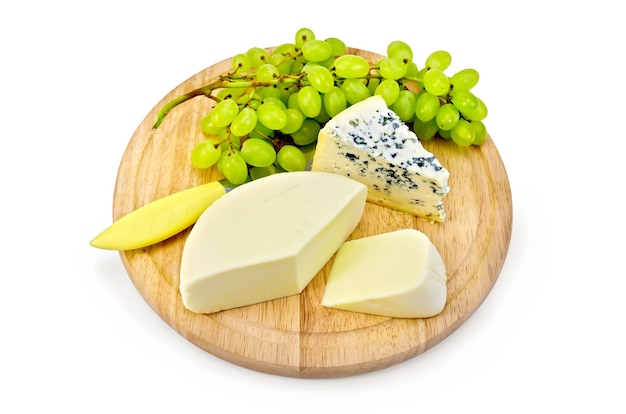 Fromage bleu, suluguni, raisins, couteau sur une planche de bois ronde isolée sur fond blanc