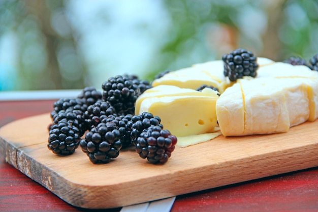 fromage avec des bleuets sur une planche de bois fromage tranché avec des baies