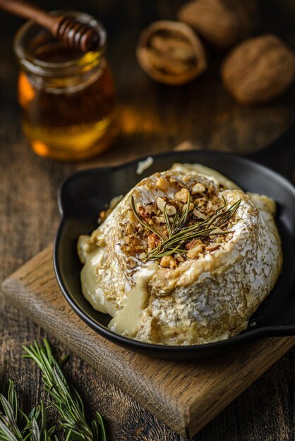 Fromage brie cuit au four sur une planche de bois