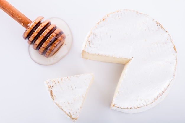 Fromage brie sur fond blanc avec ingram et miel frais