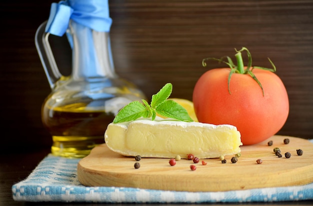 Fromage brie et huile d'olive sur fond sombre