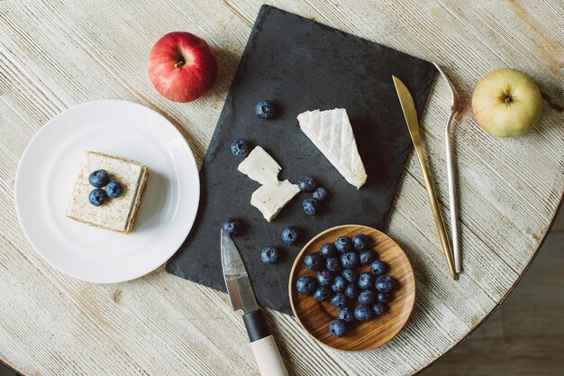 Fromage brie avec moisissure et pomme aux bleuets sur une table