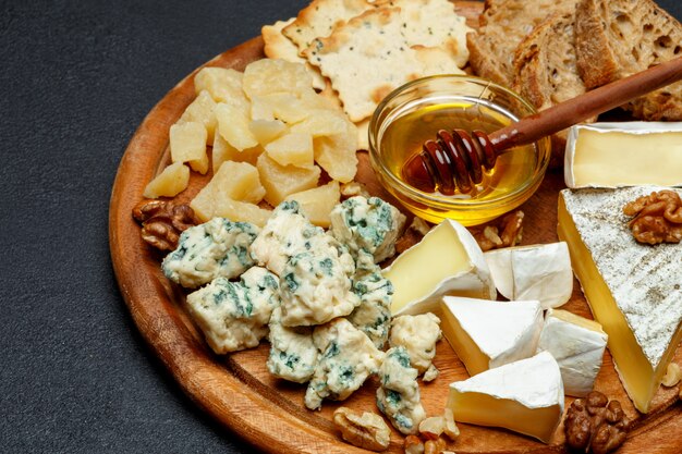 Fromage brie sur une planche de bois avec du pain et du miel doux