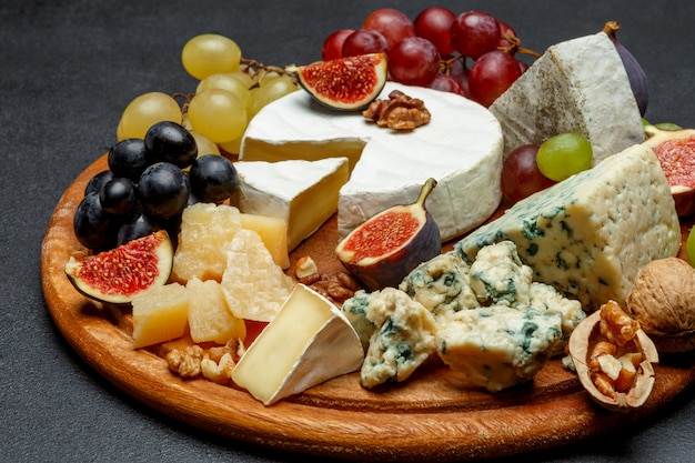 Fromage brie sur une planche de bois avec figues et raisins frais