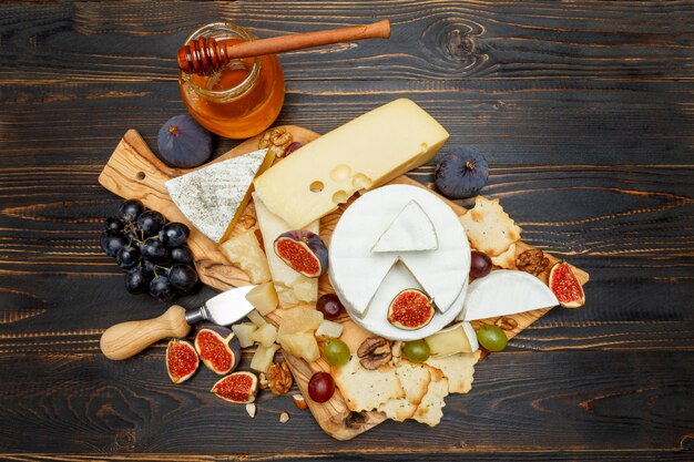 Fromage brie sur une planche de bois avec figues et raisins frais