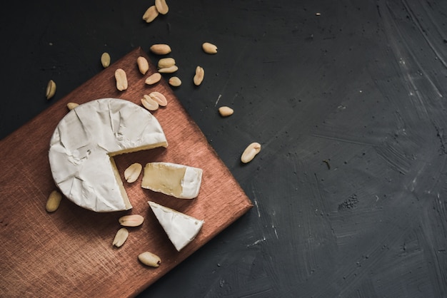 Fromage camembert coupé avec des arachides dispersées