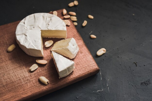 Fromage camembert avec moule et noix sur planche de bois