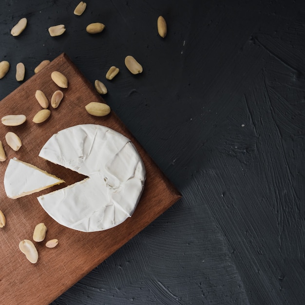 Fromage camembert avec moule et noix sur la planche à découper en bois