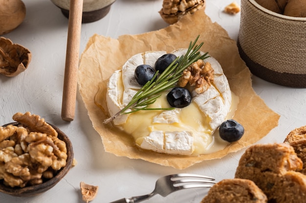 Fromage camembert sur papier myrtilles noix miel sandwicheson sur fond gris italien français