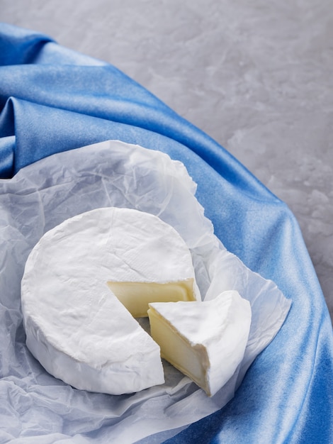 Fromage camembert sur serviette bleue. Fromage blanc sur la surface du ciment. Espace de copie