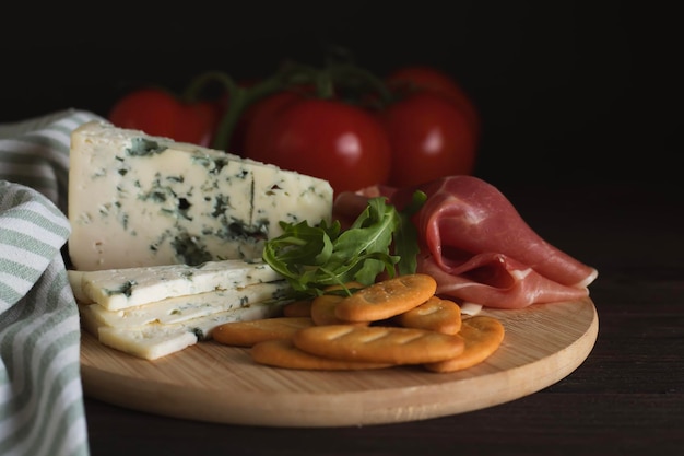 Fromage et charcuterie sur un plateau en bois sur une table en bois