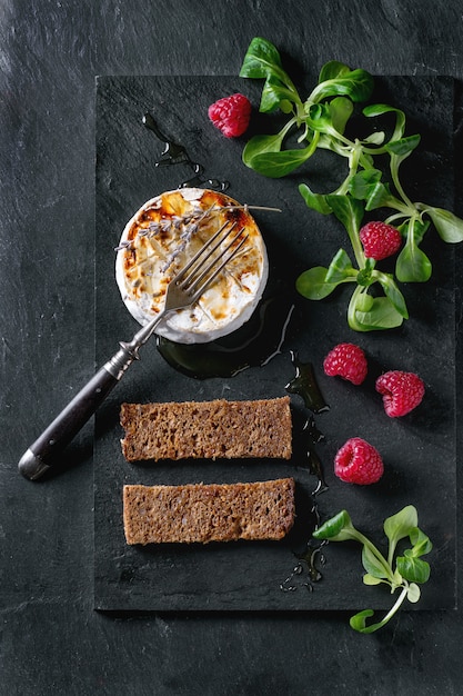 Fromage de chèvre au four avec du miel et des framboises