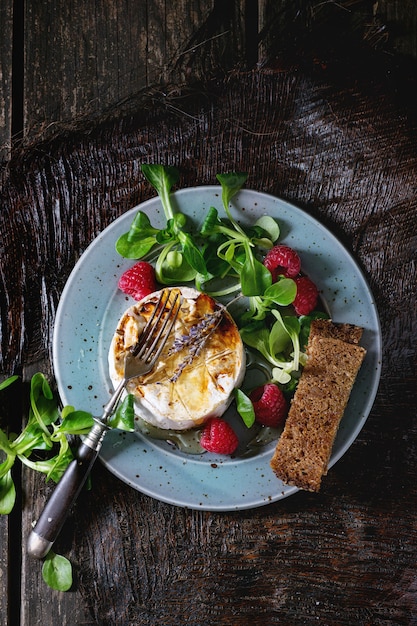 Fromage de chèvre au four avec du miel et des framboises