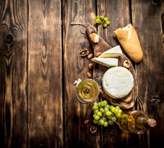 Fromage de chèvre au vin blanc et noix. Sur une table en bois.