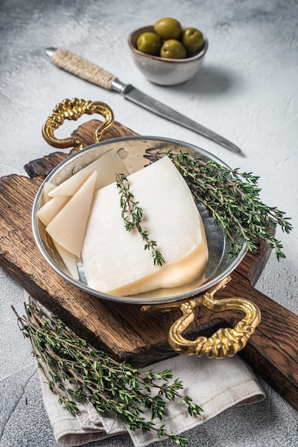 Fromage de chèvre à pâte dure français dans une poêle aux herbes Fond blanc Vue de dessus