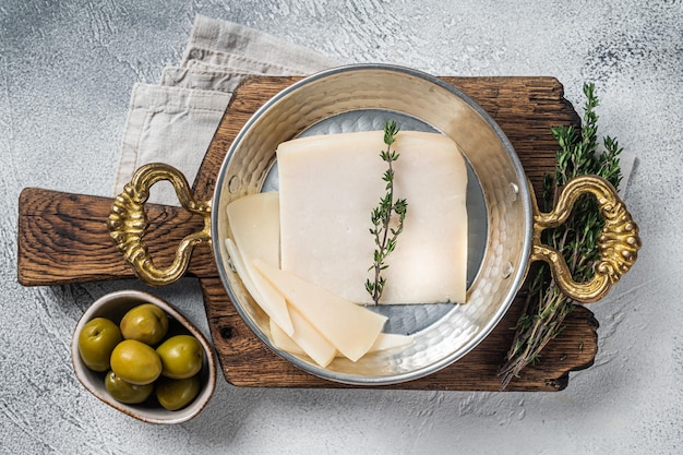 Fromage de chèvre à pâte dure français dans une poêle aux herbes Fond blanc Vue de dessus