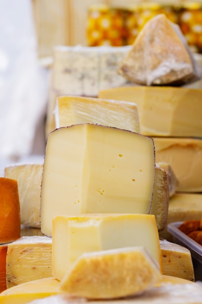 Fromage de chèvre à pâte dure sur la table. De nombreuses variétés de fromages artisanaux sont au comptoir lors de la fête du fromage. Concept de vente de produits laitiers