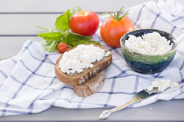 Fromage cottage de l'agriculture biologique dans un bol vert tranche de pain de blé entier avec fromage ricotta