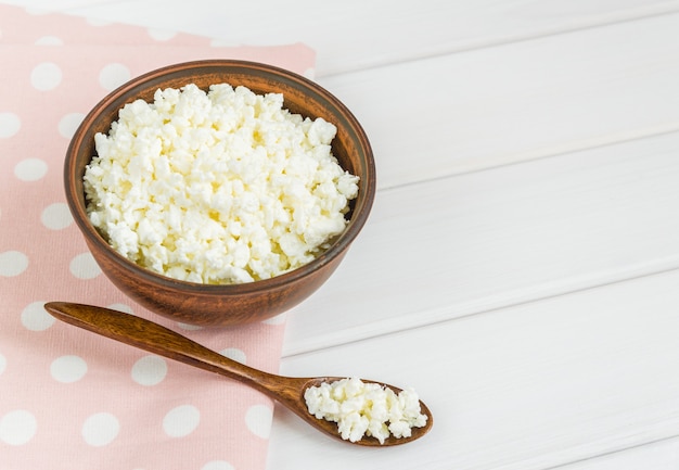 Fromage cottage aux pommes pour le petit déjeuner dans un bol de près. serviette rose à pois.