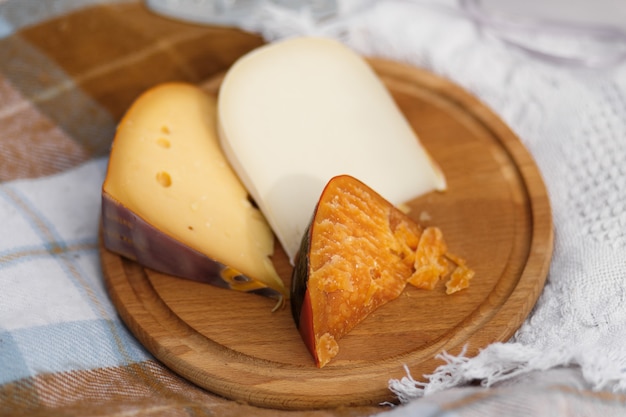 Fromage coupé sur une plaque de bois.