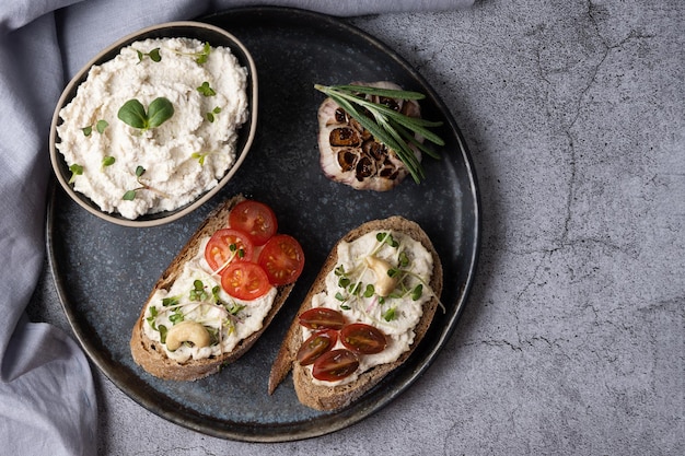 Fromage à la crème végétalien fait maison à base de noix de cajou fermentées et de sandwichs aux légumes sur fond gris