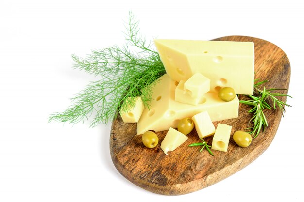 Fromage emmental tranché avec vert et olives sur la planche à découper en bois, l'espace.